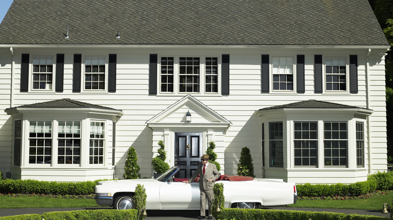Man standing in front of a white house