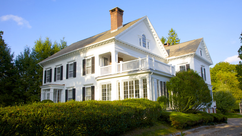 Large stately looking white house with black shutters