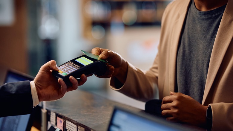 a man uses his credit card to pay at a hotel