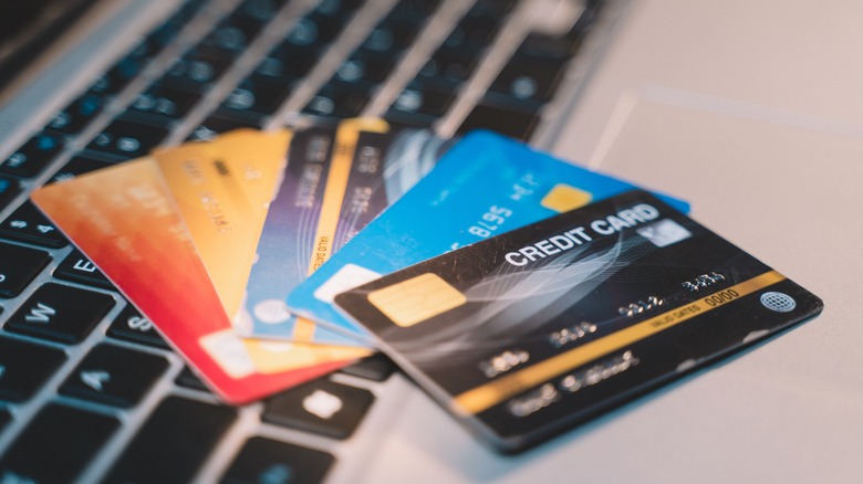 a pile of credit cards on a laptop keyboard