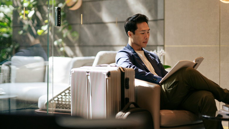 Affluent man sitting with luggage.