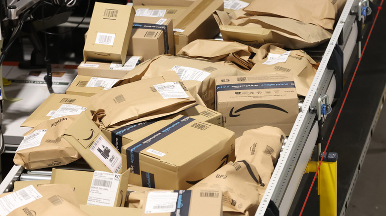 a large pile of Amazon boxes on a conveyer belt in an Amazon warehouse