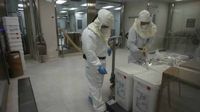 Scientists in hazmat suits working in a lab