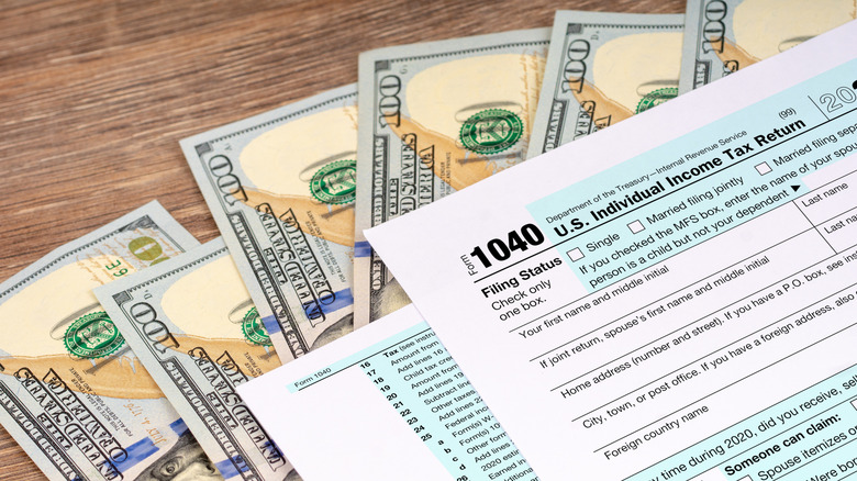 IRS tax forms on top of $100 bills