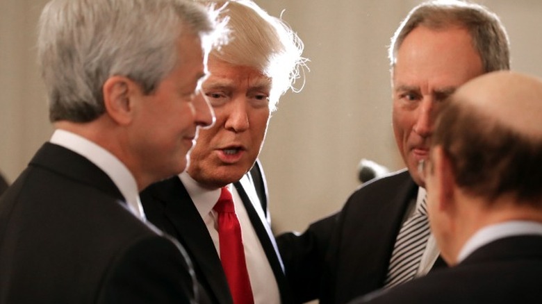 Donald Trump standing with JPMorgan CEO Jamie Dimon and two others during the president's first term.