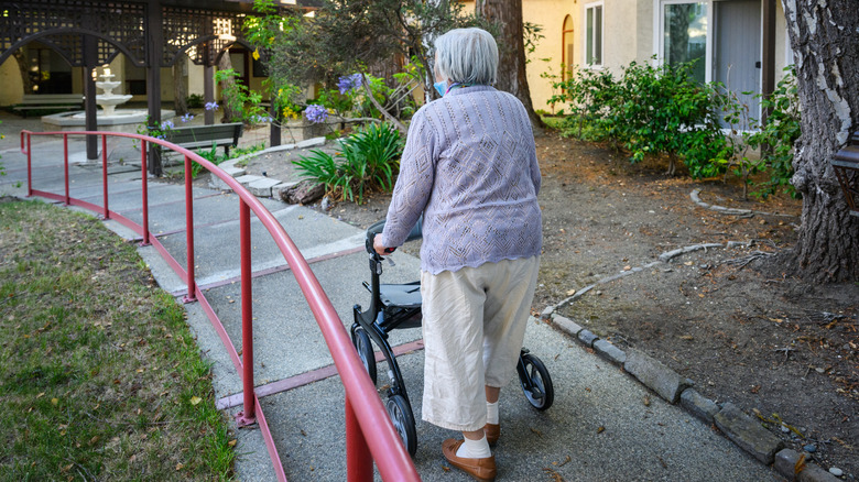 Elderly woman on a walker outside