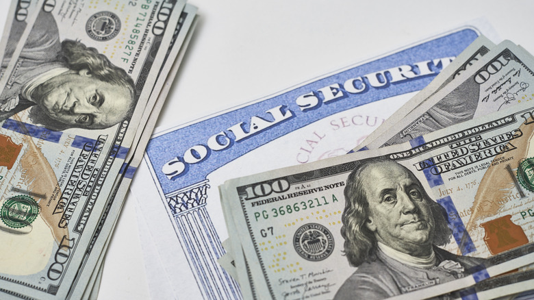 Social Security card near $100 bills on a table or desk