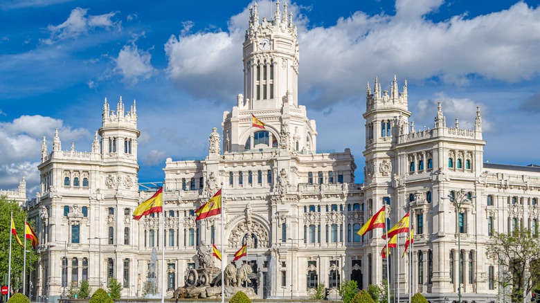 Picture of a large castle with numerous Spanish flags in front