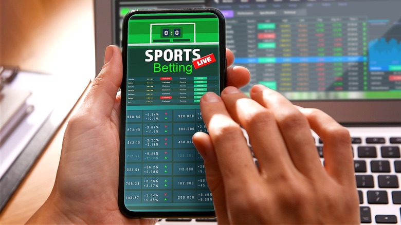 Person betting sports on smartphone