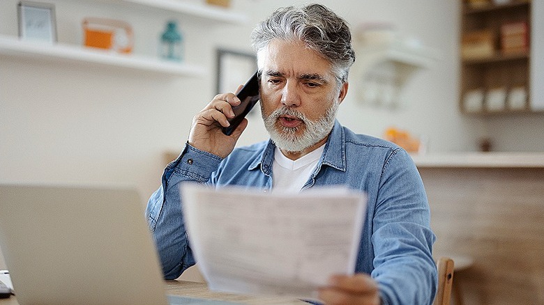 Person on phone with paperwork