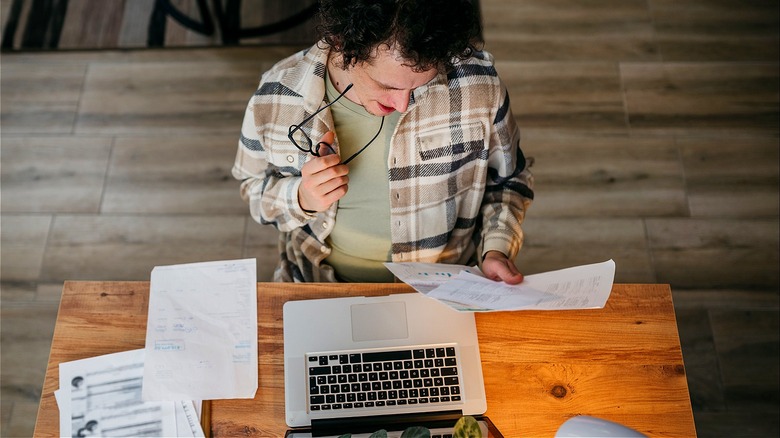 Person at home, reviewing paperwork