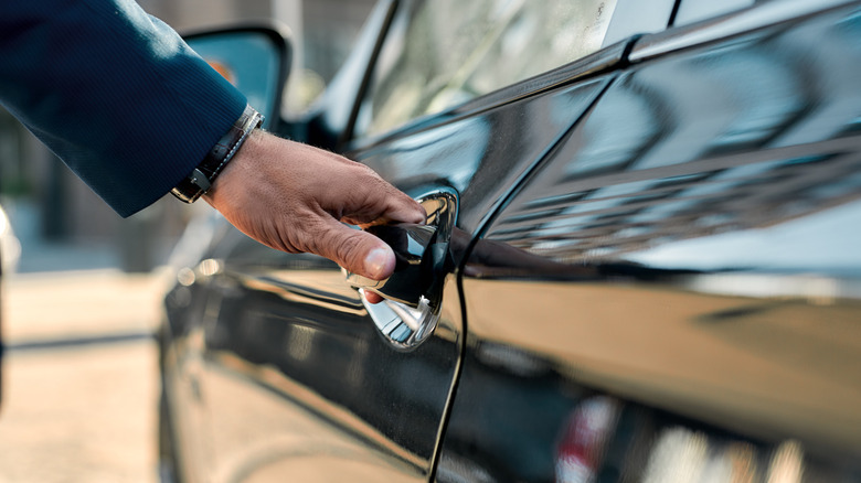 Man opening door handle to car