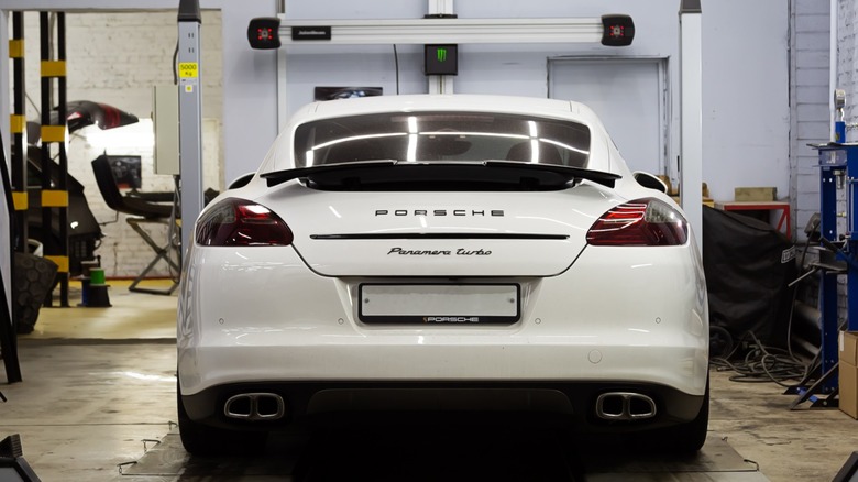 White 2018 Porsche Panamera Turbo getting a wheel alignment at a service shop