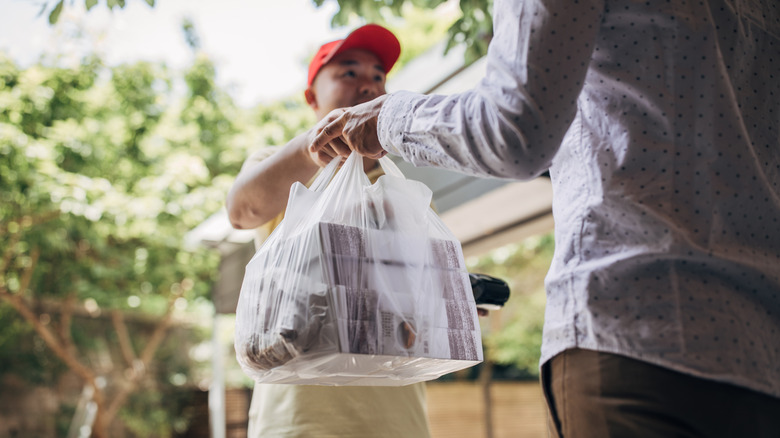 A delivery driver dropping food off for a customer