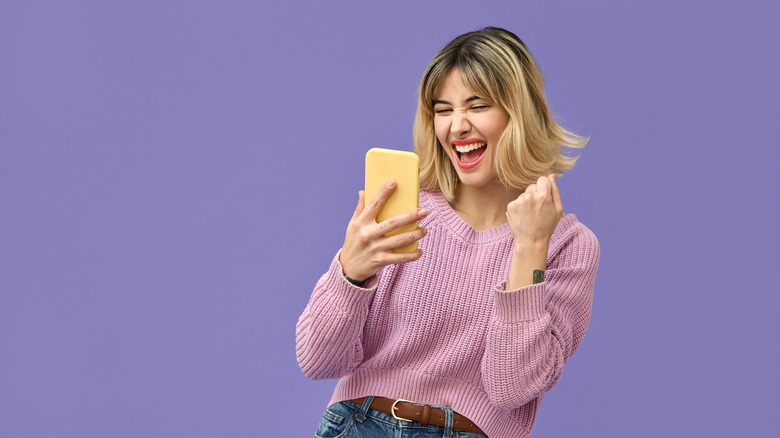 woman winning the lottery holding phone