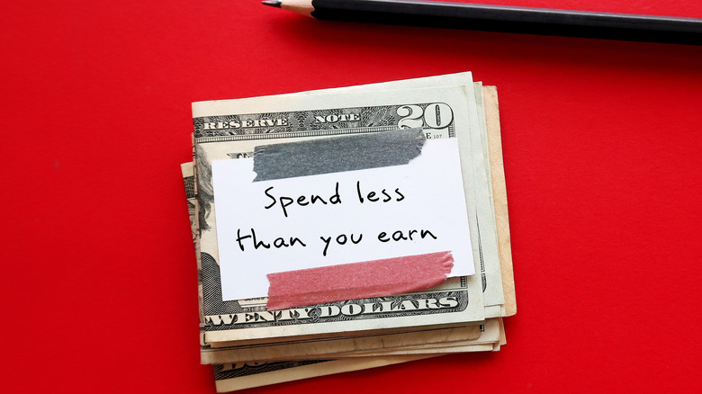 A note on money reading "Spend less than you earn"
