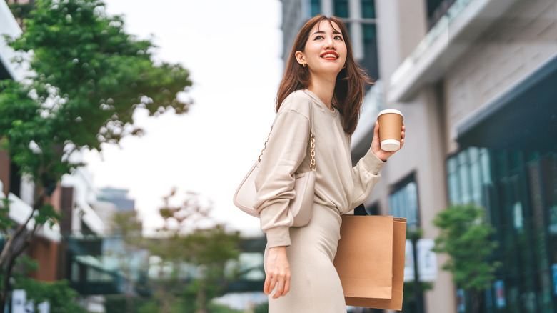 A young woman smiling with a cup of coffee in her hand