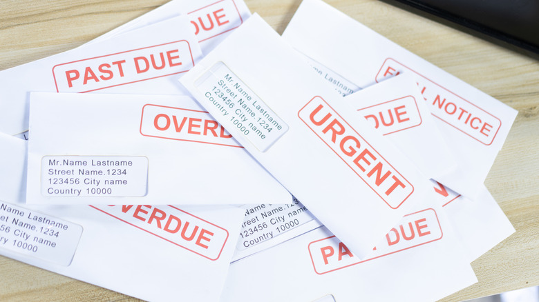 overdue bills in envelopes on a wooden table