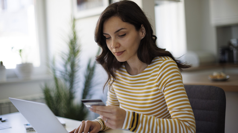 A woman sitting in an office orders something with her credit card