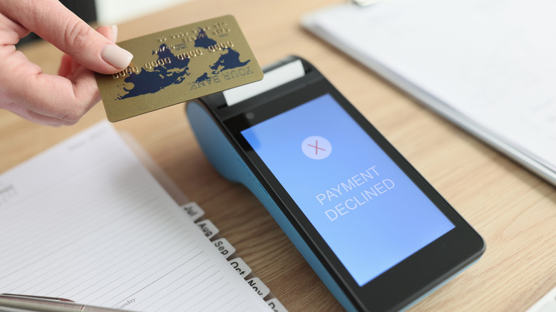 A credit card reader displays a "payment declined" message as someone tries to make a payment
