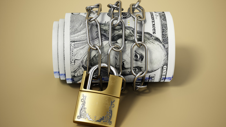 lock and chain around a roll of money