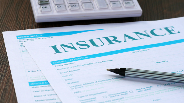 insurance paperwork and a calculator