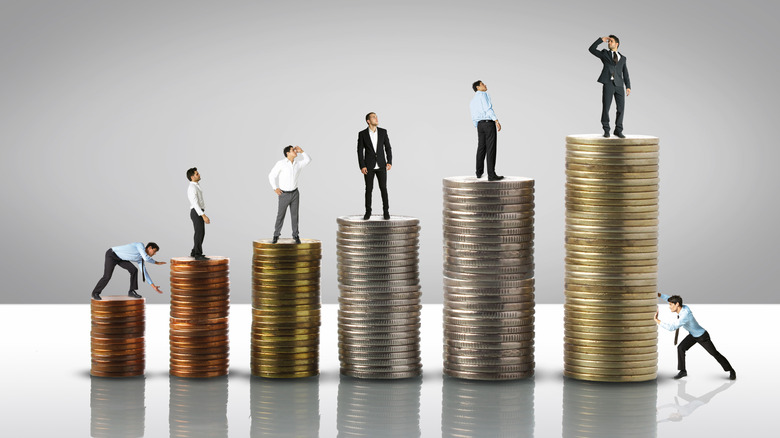 people standing on stacks of coins