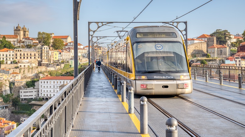 Porto Metro train runs along the Ponto do Freixo Bridge in Porto, Portugal.