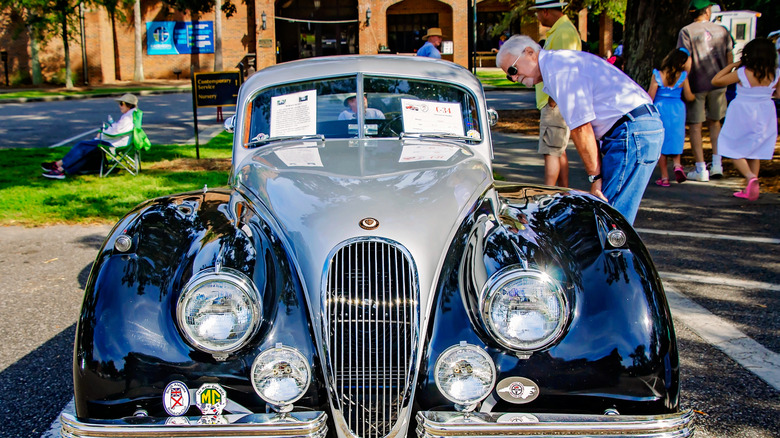 A man looking at a luxury car at The British Car festival in Alabama.