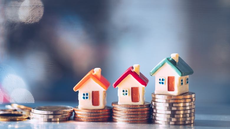 Stacks of coins with home miniatures on top