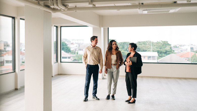 Couple meeting with a real estate agent in an empty apartment