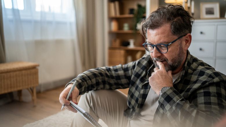 Worried man looking at a pad of paper