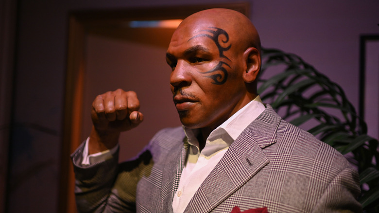 Mike Tyson in a suit making a fist