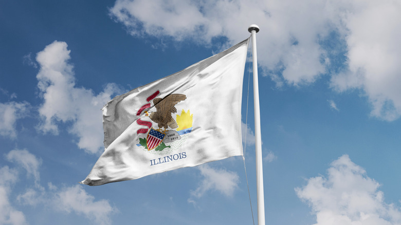 Illinois state flag waving with a blue-sky background.