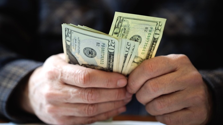 Person holding several $20 bills