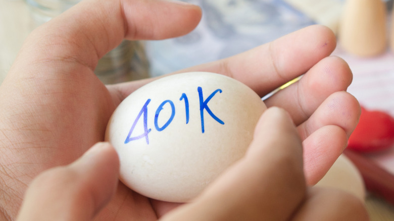 Retirement 401(k) plan represented by egg in hand with "401k" written on it