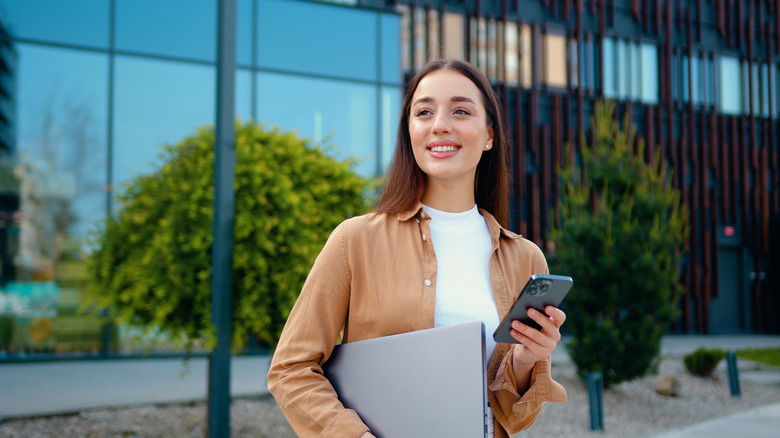 Woman outside an office building holding a phone