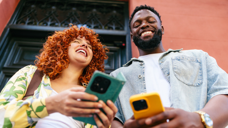 Two young looking people on their phones
