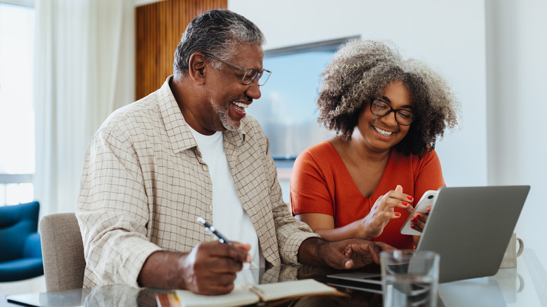 A couple reviews their financial records to save for retirement.