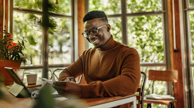 A smiling middle-aged man going over his finances