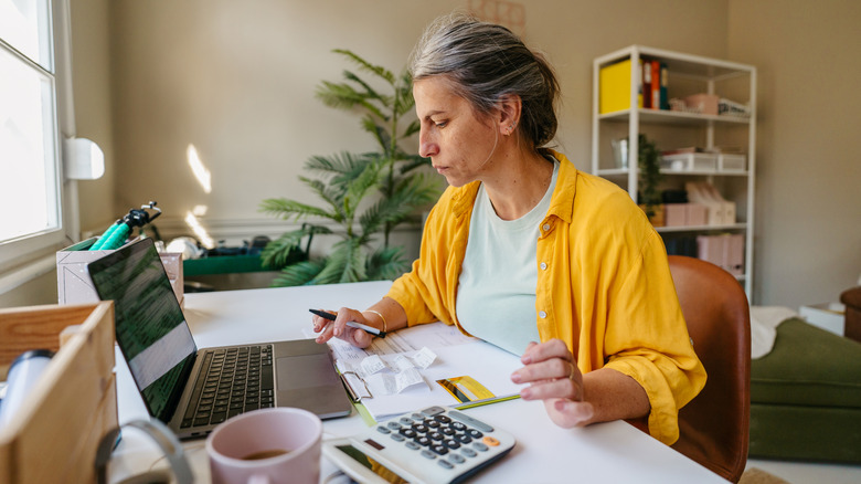 A woman looking at paperwork in her home.