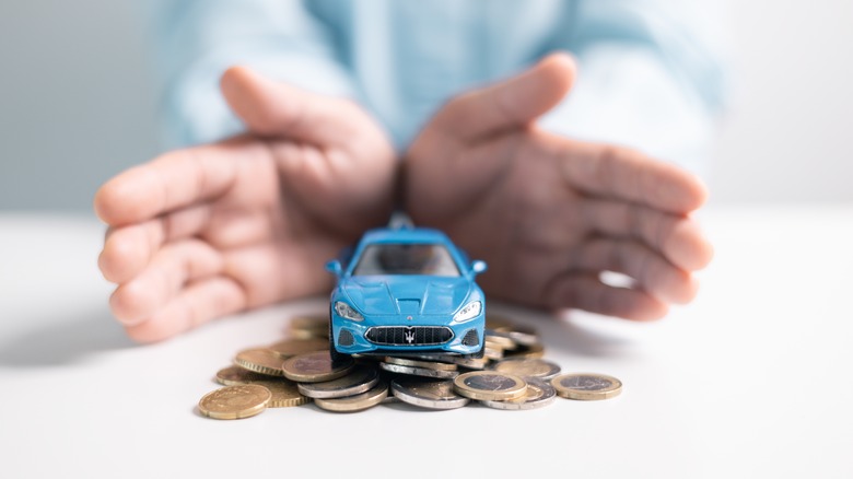 Toy car on top of stack of coins.