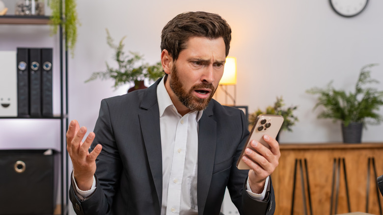 A young investor baffled by news on his phone