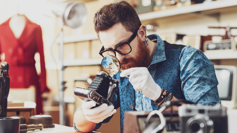 collector inspecting an antique camera