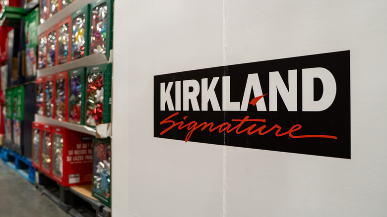 A Kirkland Signature sign on display at Costco beside shelves lined with products