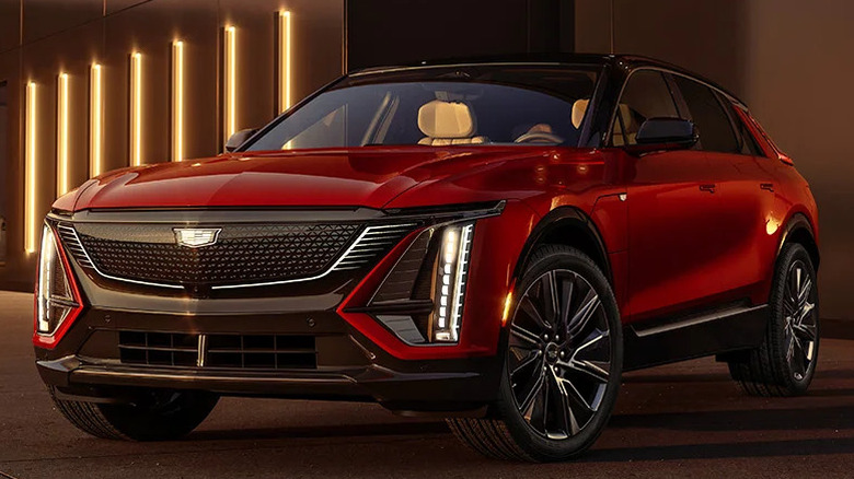 red 2024 Cadillac Lyriq parked indoors in front of long, vertical wall-mounted lighting