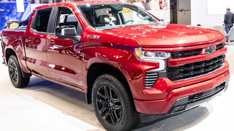 Red Chevrolet Silverado pickup truck on display indoors, featuring black wheels and a Z71 badge on the front fender