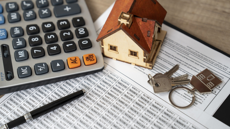 A calculator, papers and keys for the house