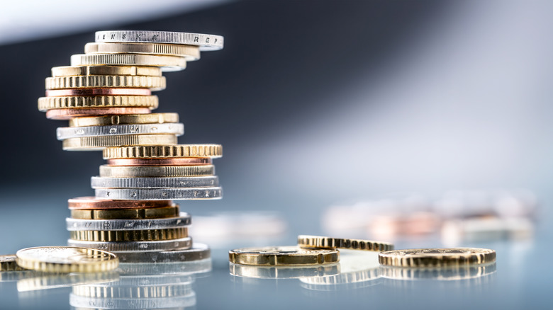 Stack of pennies and other coins on table.