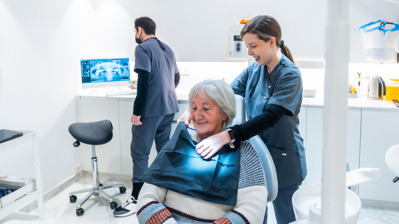 A senior woman in a dentist's chair preparing for a check up.